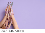 Женские руки с художественными кистями и мастихином на лиловом фоне. Стоковое фото, фотограф Pixel_shot / Фотобанк Лори