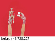 Мумия руки с скелетом и таблетками на красном фоне. Празднование Хэллоуина. Стоковое фото, фотограф Pixel_shot / Фотобанк Лори