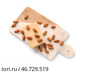 Разделочная доска с вкусным марципановым батончиком и миндальными орехами на белом фоне. Стоковое фото, фотограф Pixel_shot / Фотобанк Лори