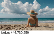 A woman on vacation, sitting in a swimsuit and a wide-brimmed straw hat on the beach on a sunny day and looking at the sea. Стоковое AI-изображение, AI-художник Photojuli / Фотобанк Лори