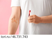 Донор крови с медицинскими пластырями и пробиркой на розовом фоне, крупный план. Стоковое фото, фотограф Pixel_shot / Фотобанк Лори