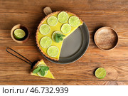 Тарелка и лопатка с вкусным лаймовым тартом на деревянном фоне. Стоковое фото, фотограф Pixel_shot / Фотобанк Лори
