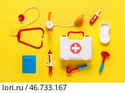 Игрушечная аптечка с стетоскопом, термометром и молоточком для проверки рефлексов на жёлтом фоне. Вид сверху. Стоковое фото, фотограф Pixel_shot / Фотобанк Лори
