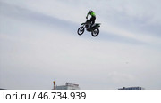 Large scale spectacle of dangerous stunts of motorcyclist flying from springboard on background of city. Редакционное фото, фотограф David Kashakhi / Фотобанк Лори