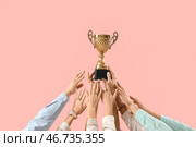 Много рук с золотым кубком на розовом фоне. Стоковое фото, фотограф Pixel_shot / Фотобанк Лори