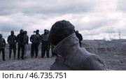 Man sits in a chair and looks at a group of masked criminals. Стоковое фото, фотограф David Kashakhi / Фотобанк Лори