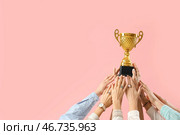 Много рук с золотым кубком на розовом фоне. Стоковое фото, фотограф Pixel_shot / Фотобанк Лори