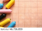Разные баллончики с аэрозольной краской на фоне из плитки. Стоковое фото, фотограф Pixel_shot / Фотобанк Лори