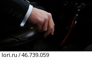 Businessman driving to work, hand shifting the gear stick. Стоковое фото, фотограф David Kashakhi / Фотобанк Лори