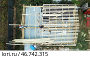 Aerial view of two senior men building a wooden frame house in the summer on their own location. Стоковое фото, фотограф David Kashakhi / Фотобанк Лори
