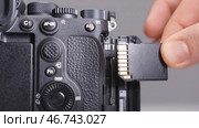 Close-up photographer inserts new memory card into camera. Редакционное фото, фотограф David Kashakhi / Фотобанк Лори