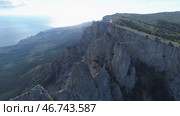 Aerial view of gorgeous white cliff and people standing with flags on the top against blue sky and sea in bright summer day. Стоковое фото, фотограф David Kashakhi / Фотобанк Лори