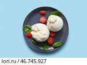 Тарелка вкусного сыра Буррата с базиликом и помидорами на голубом фоне. Стоковое фото, фотограф Pixel_shot / Фотобанк Лори