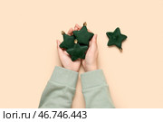 Женские руки с звездообразными рождественскими украшениями на цветном фоне, крупным планом. Стоковое фото, фотограф Pixel_shot / Фотобанк Лори