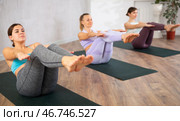 Young focused women doing boat pose in yoga studio. Стоковое фото, фотограф Яков Филимонов / Фотобанк Лори