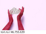 Женские руки, покрытые блестками, и красивый диадема на лиловом фоне, крупным планом. Стоковое фото, фотограф Pixel_shot / Фотобанк Лори
