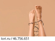 Женские ноги с лейкопластырем и колючей проволокой на бежевом фоне. Концепция неудобной обуви. Стоковое фото, фотограф Pixel_shot / Фотобанк Лори