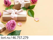 Элегантные обернутые подарочные коробки с розами на желтом фоне. Стоковое фото, фотограф Pixel_shot / Фотобанк Лори