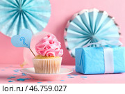 Вкусный кекс с вопросительным знаком, подарочной коробкой и украшениями на розовом фоне. Концепция вечеринки по раскрытию пола ребенка. Стоковое фото, фотограф Pixel_shot / Фотобанк Лори