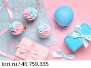 Вкусные кексы с подарочными коробками и украшениями на розовом фоне. Концепция вечеринки с раскрытием пола. Стоковое фото, фотограф Pixel_shot / Фотобанк Лори