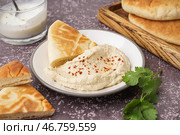 Тарелка вкусного пита-хлеба с хумусом на сером фоне. Стоковое фото, фотограф Pixel_shot / Фотобанк Лори