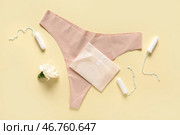 Менструальная прокладка с тампонами и трусами на желтом фоне. Стоковое фото, фотограф Pixel_shot / Фотобанк Лори