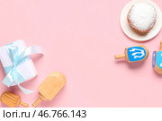 Композиция к Хануке с кружками, пончиками и подарочной коробкой на розовом фоне. Стоковое фото, фотограф Pixel_shot / Фотобанк Лори