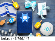 Композиция кану́ки с Тора, мено́рой, крутя́щимися топора́ми и подаро́чными коро́бками на си́ний деревя́нный фо́н. Стоковое фото, фотограф Pixel_shot / Фотобанк Лори