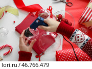 Женщина держит клеевой пистолет и украшает рождественскую шарик ринестонами на столе. Стоковое фото, фотограф Pixel_shot / Фотобанк Лори