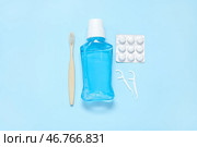 Жевательные резинки с зубной щеткой, мундштуком и зубной нитью на голубом фоне. Стоковое фото, фотограф Pixel_shot / Фотобанк Лори
