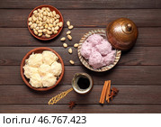Миски с вкусным турецким писманием, фисташками и джезвой с кофе на деревянном фоне. Стоковое фото, фотограф Pixel_shot / Фотобанк Лори