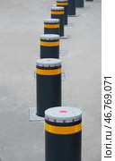 Дорожный блокиратор в виде выдвижных металлических столбов. The barrier is automatic in a parking lot in a modern city. Стоковое фото, фотограф Татьяна Д / Фотобанк Лори