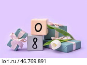 Кубический календарь с датой 08, красивым белым тюльпаном и подарочными коробками на лиловом фоне. Международный женский день. Стоковое фото, фотограф Pixel_shot / Фотобанк Лори
