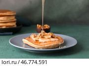 Лить мед на вкусный блин с нарезанным бананом и грецкими орехами на столе. Стоковое фото, фотограф Pixel_shot / Фотобанк Лори