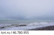 Штормовые волны на Черном море зимой в БАтуми.  Драматичный морской пейзаж с бушующими волнами, накатывающими на галечный пляж под серым пасмурным небом. Вдалеке на горизонте видны грузовые корабли, создавая атмосферу путешествий и природной стихии. Мощь природы ощущается в каждой детали этого кадра. Стоковое видео, видеограф Анна Чижова / Фотобанк Лори