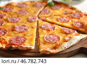 Вкусная нарезанная пицца пепперони на деревянной доске, крупным планом. Стоковое фото, фотограф Pixel_shot / Фотобанк Лори