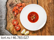 Вкусный томатный суп с креветками в тарелке на деревянном столе. Стоковое фото, фотограф Pixel_shot / Фотобанк Лори