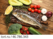 Доска с вкусно приготовленной сибасом, рыбой и овощами на деревянном фоне. Стоковое фото, фотограф Pixel_shot / Фотобанк Лори