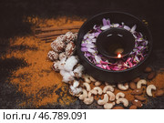 Чаша с горящей свечой и лепестками цветов для празднования Дивали на темном фоне. Стоковое фото, фотограф Pixel_shot / Фотобанк Лори
