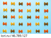 Сырые макароны фарфалле на цветном фоне. Стоковое фото, фотограф Pixel_shot / Фотобанк Лори
