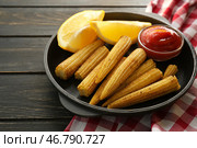 Сковорода с вкусными кукурузными початками, лимоном и соусом на деревянном столе. Стоковое фото, фотограф Pixel_shot / Фотобанк Лори