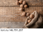 Мешочек с вкусными грецкими орехами на деревянном столе. Стоковое фото, фотограф Pixel_shot / Фотобанк Лори