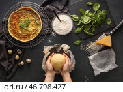Женщина готовит вкусный пирог со шпинатом на темном фоне. Стоковое фото, фотограф Pixel_shot / Фотобанк Лори