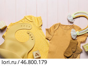 Детская одежда, слюнявчик и игрушка на цветном деревянном фоне, крупным планом. Стоковое фото, фотограф Pixel_shot / Фотобанк Лори