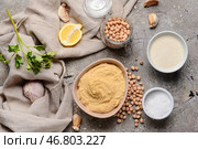 Композиция с вкусным хумусом и ингредиентами на фоне гранж. Стоковое фото, фотограф Pixel_shot / Фотобанк Лори