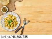 Тарелка с вкусными клецками и соусом песто на деревянном фоне. Стоковое фото, фотограф Pixel_shot / Фотобанк Лори