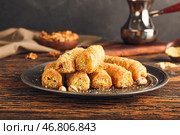 Тарелка с вкусной пахлавой на деревянном фоне. Стоковое фото, фотограф Pixel_shot / Фотобанк Лори
