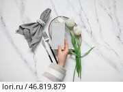 Женщина держит пустую пригласительную открытку у сервированного стола с тюльпанами. Стоковое фото, фотограф Pixel_shot / Фотобанк Лори
