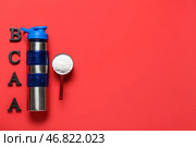 Бутылка воды, буквы BCAA и совок с аминокислотной добавкой на красном фоне. Стоковое фото, фотограф Pixel_shot / Фотобанк Лори
