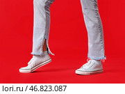 Женские ноги в стильных кедах на красном фоне, крупным планом. Стоковое фото, фотограф Pixel_shot / Фотобанк Лори